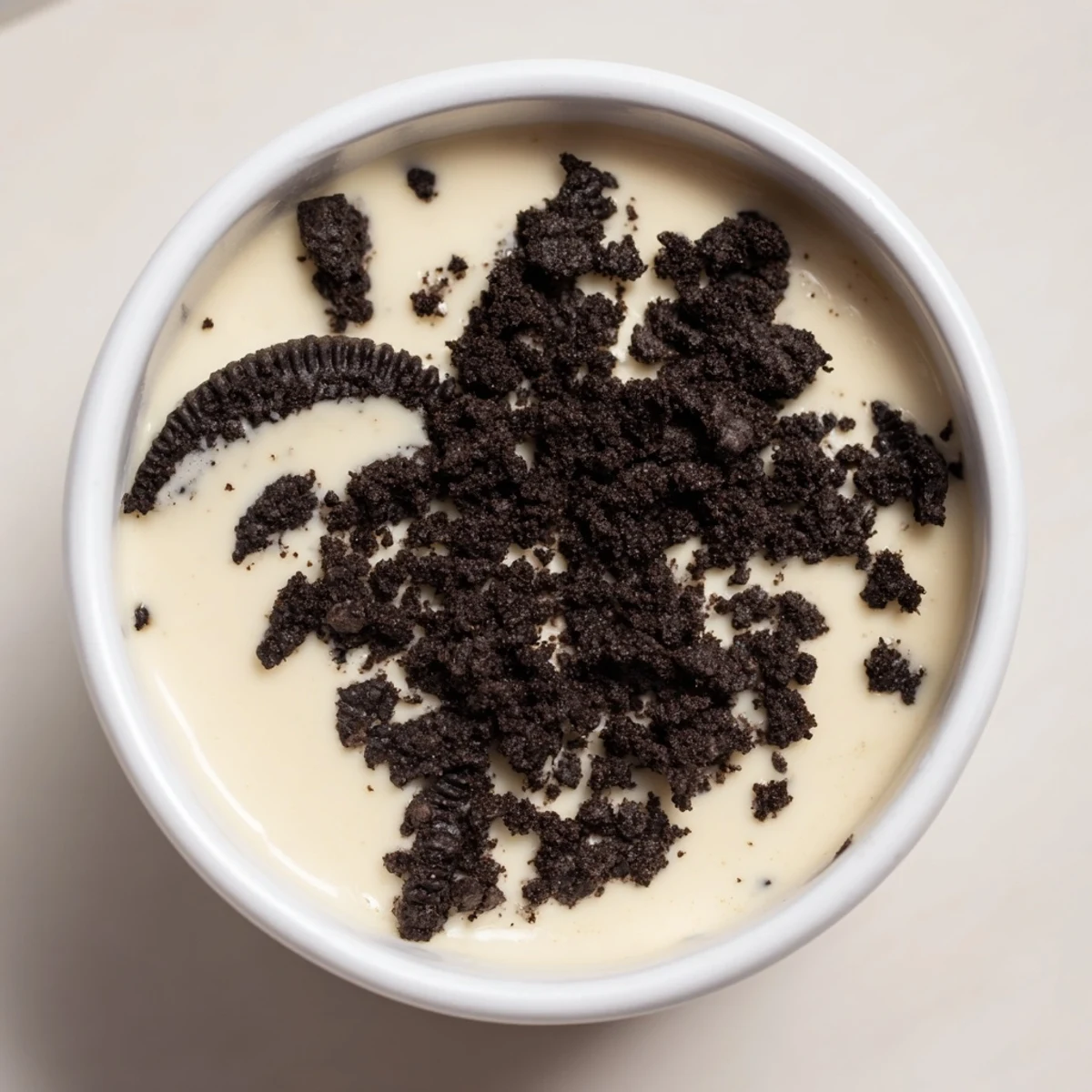 Creamy vanilla pudding with Oreo topping, perfect for dessert; imagine the delicious texture.