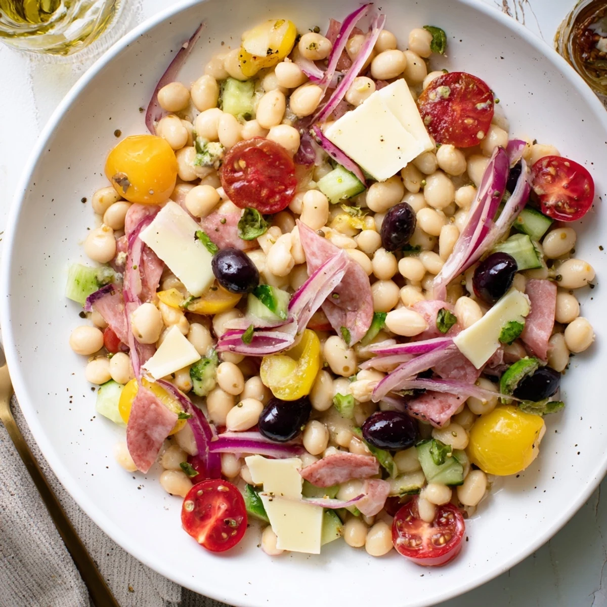 Italian Antipasto Bean Salad, brimming with colorful veggies, salami, and tangy dressing, perfect for sharing.