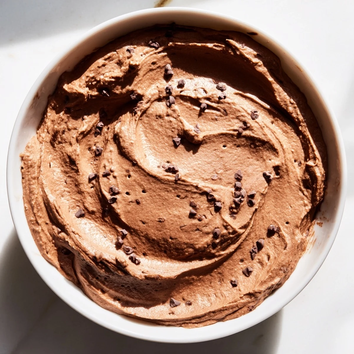 A photo shows delightfully smooth, rich chocolate hummus ready for snacking with fresh fruit.