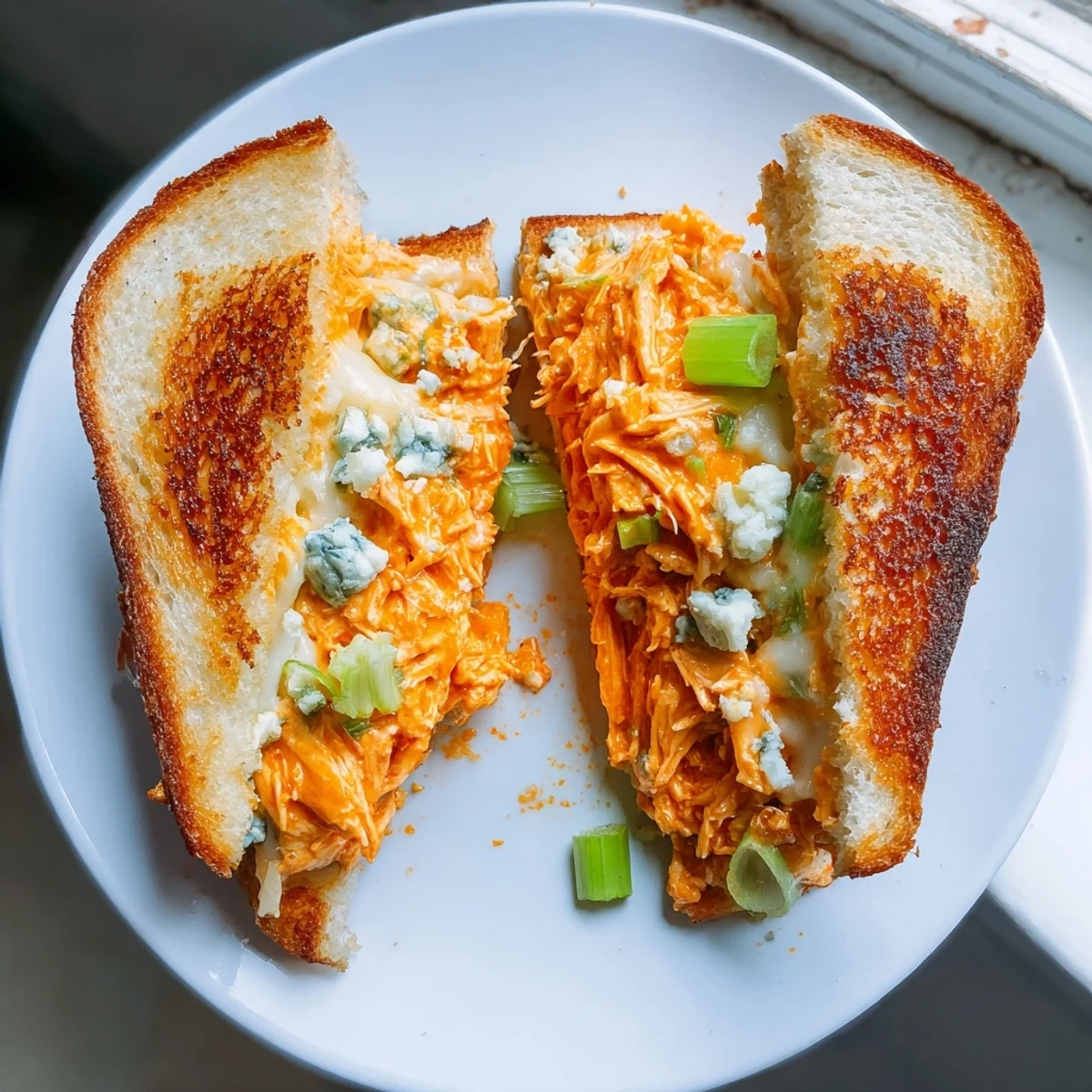 Golden, toasted sourdough holding a generous filling in this amazing Buffalo Chicken Grilled Cheese.