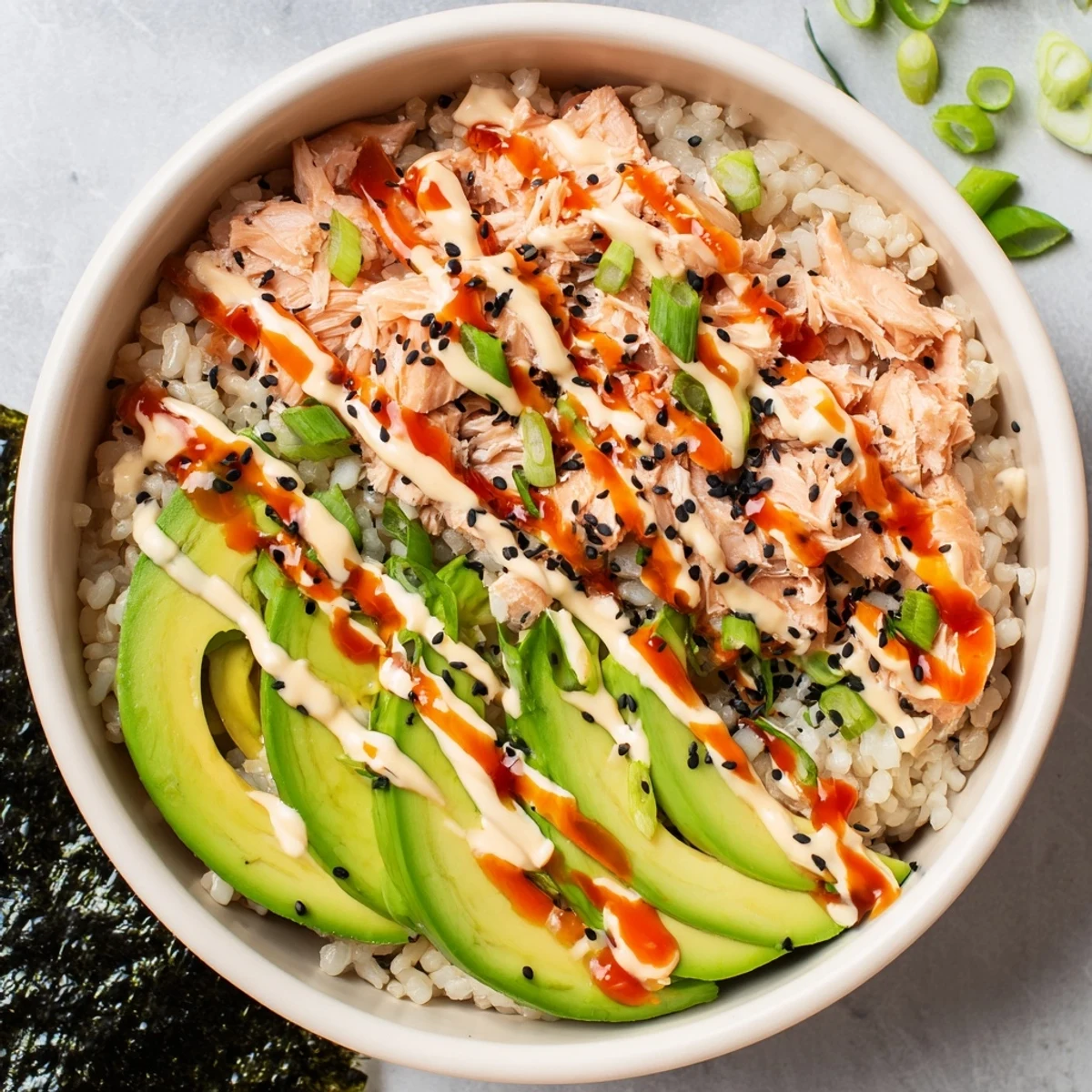A freshly prepared Emily Mariko Salmon Rice Bowl served with crispy roasted seaweed sheets for wrapping each savory bite.