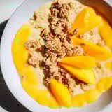 A refreshing breakfast idea: creamy Mango Blended Overnight Oats, layered with crunchy granola in a jar.