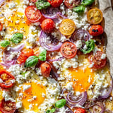 Sheet pan Tomato Feta Baked Eggs featuring sunny-side-up eggs, bursting tomatoes, and crumbled feta.