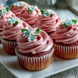 Soft and fluffy cupcakes adorned with intricate buttercream roses, peonies, and leaves in pastel shades.  
