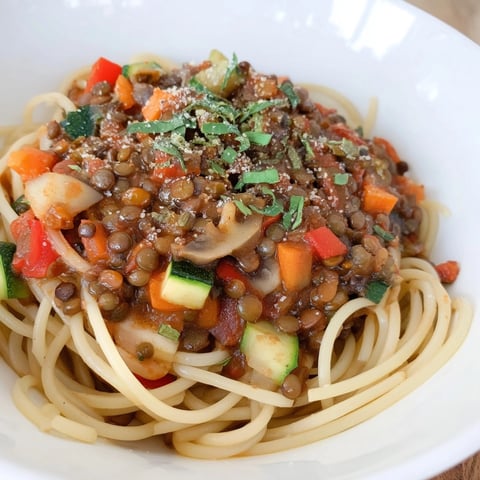 A close-up of hearty 25-minute Lentil Bolognese, glistening with vibrant tomato sauce.