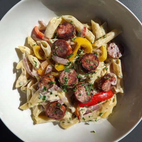 Smoked Sausage Cajun Alfredo with penne pasta, a creamy dish featuring browned sausage and colorful peppers.