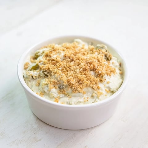 A vibrant image of creamy Fried Pickle Dip, ready to be scooped up with crunchy chips.