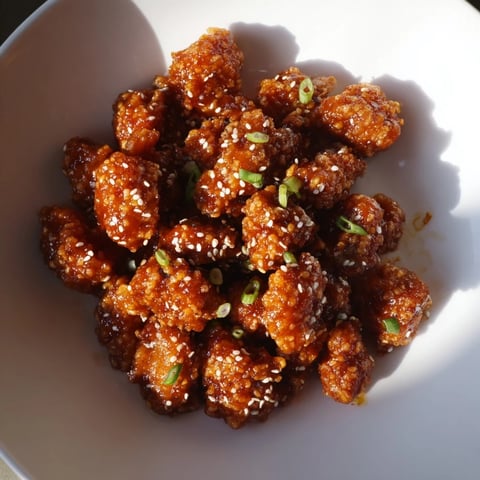 Honey-Sriracha Chicken Bites glistening, sticky with sauce, ready to serve as a perfect appetizer.