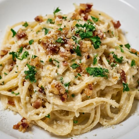 Golden-brown crispy bacon and garlic in creamy garlic bacon pasta, ready to eat.