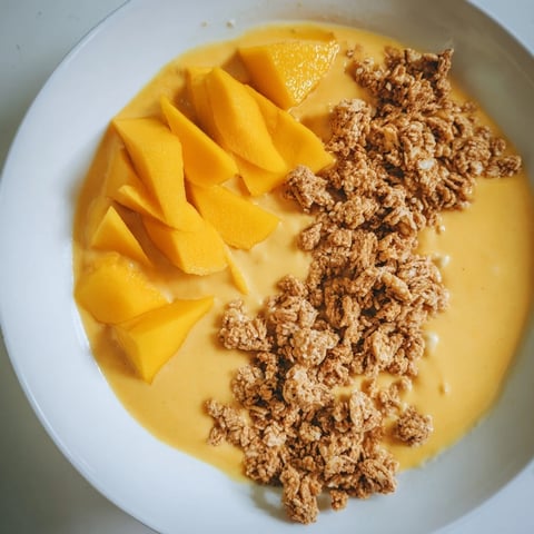 Vibrant image of Mango Blended Overnight Oats, showcasing a creamy texture with fresh mango slices on top.