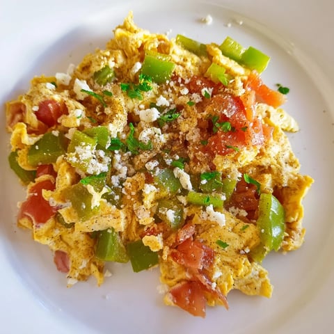 Sizzling Turkish Menemen scramble, fragrant with tomatoes and peppers, served hot with crusty bread.