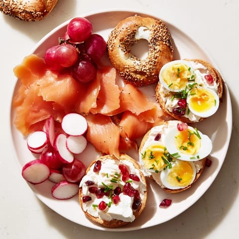 A delightful assortment: cranberry bagels, creamy cheeses, and colorful garnishes arranged on a shareable brunch platter.