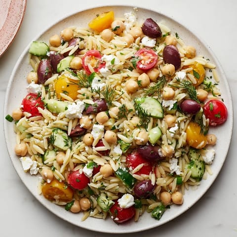 A bowl of colorful Greek Lemon-Orzo Bean Salad, a light and refreshing vegetarian meal option.