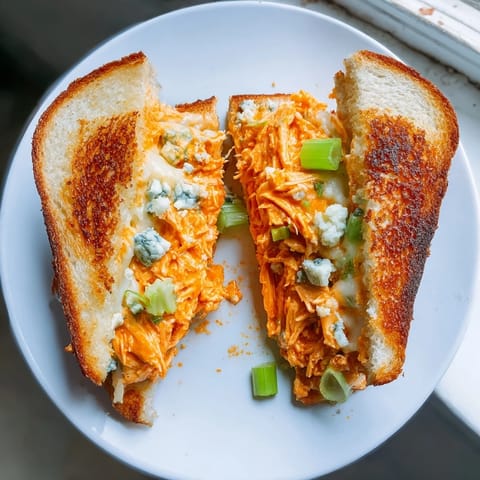 Golden, toasted sourdough holding a generous filling in this amazing Buffalo Chicken Grilled Cheese.
