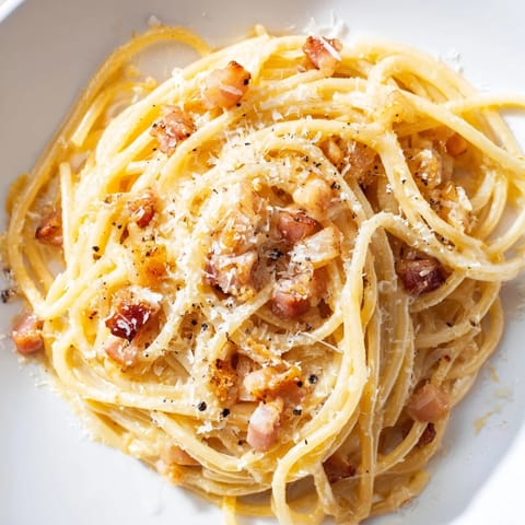 Close-up of golden, crispy bacon bits topping a bowl of rich Express Spaghetti Carbonara.
