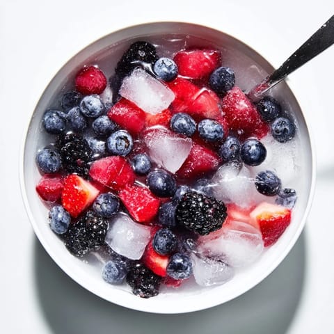 Sun-drenched photo of Nature's Cereal Bowl with mixed berries and coconut water, served in a white ceramic bowl.