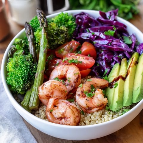 A colorful, nutrient-packed bowl with steamed asparagus, crisp red cabbage, juicy tomatoes, and tender shrimp, perfect for a light and healthy lunch.