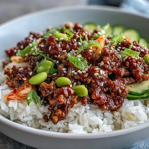 Spicy gochujang ground beef in a Korean Ground Beef Bowl topped with edamame and green onions on steamed rice