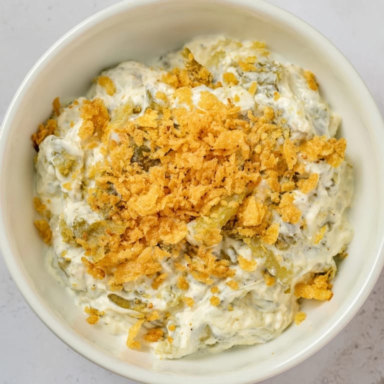 Close-up of a bowl of Fried Pickle Dip, showcasing the tangy, pickle-filled texture and perfect for dipping.