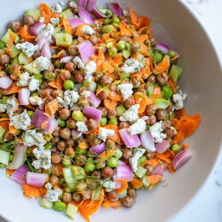 Hearty buffalo chicken bean salad with tender chickpeas, ready to enjoy with tortilla chips.