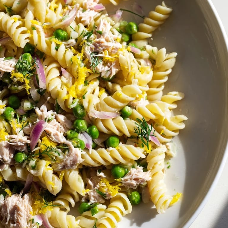 This chilled Lemony Tuna Pasta Salad combines tender pasta, crisp red onion, and dill, ideal for a refreshing summer picnic lunch.