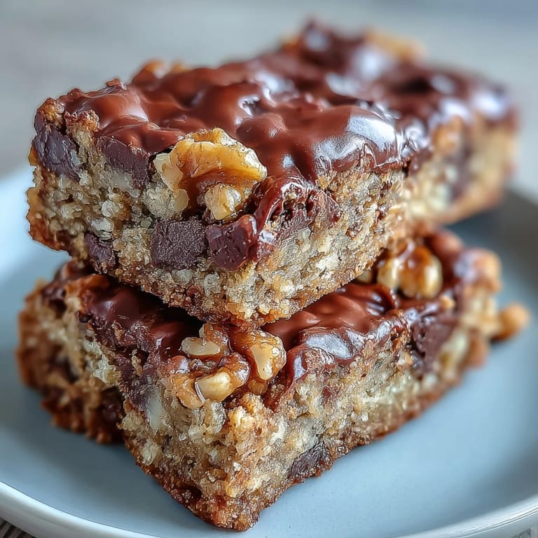 Sliced Chunky Monkey Protein Baked Oat Bars reveal chocolate chunks and walnuts on a rustic plate.