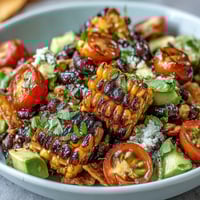 Grilled Corn and Black Bean Taco Salad with charred corn, black beans, and crisp veggies tossed in zesty lime dressing.