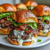 Melted cheddar cheese crowns these Easy Father's Day Grilled Bacon Burger Sliders.